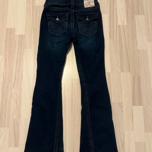 True Religion Jeans - Mid Waist bootcut mörkblå jeans från true religion storlek 27/32. På mig som är ca 170 går dom hela vägen ner i golvet. 