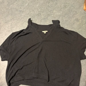 Svart ribbad polotopp från H&M - Svart ribbad polotopp från H&M i storlek XXL. Toppen har korta ärmar, v-ringning och en uppvikt krage som ger en chill och modern vibe. Perfekt för dig som gillar en enkel men ändå snygg look.