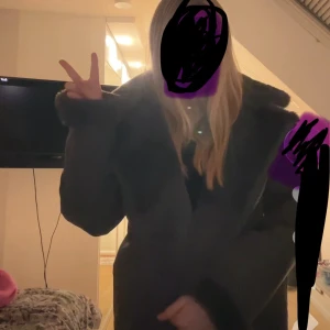 Mörkgrå teddyjacka med dragkedja - Säljer en mörkgrå teddyjacka från divided med stor fluffig krage och muddar. Jackan har dragkedja i sidan och är helfodrad med mjukt teddyfoder. Perfekt för kalla dagar och ger en cool look. 