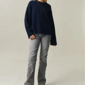 Mörkblå stickad tröja från gina tricot - Mysig mörkblå stickad tröja från gina tricot med rund halsringning och långa ärmar. Tröjan har en loose passform och ribbade muddar vid ärmslut och nederkant. Perfekt för lager-på-lager under kyliga dagar. Tröjan har en liten defekt men som inte alls syns, lätt att laga🥰