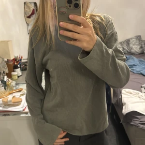 Grå ribbad långärmad tröja Bik Bok - Enkel och stilren grön långärmad tröja från Bik Bok i ribbat material. Tröjan har rund halsringning och en rak passform som är lätt att matcha med olika outfits. Perfekt för lager-på-lager och chill dagar.