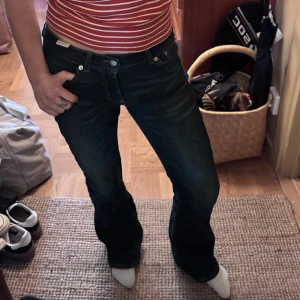 Mörkblå lågmidjade bootcut jeans från junkyard - Nypris: 700kr. Säljer ett par mörkblå jeans med bootcut passform. Klassisk med snygga detaljer på bakfickorna och silverfärgade knappar. Jeansen har låg midja och är i jättebra skick. Pris kan diskuteras!