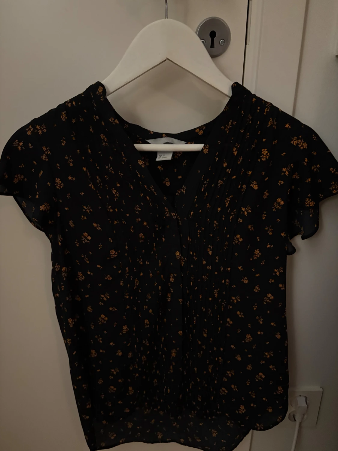 Svart blommig blus med kort ärm