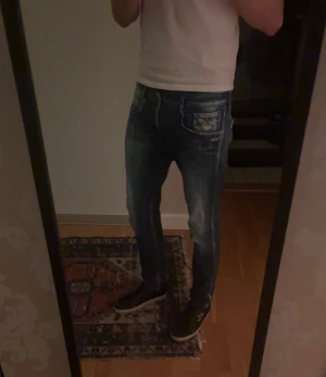 Replay Anbass 32/32 - Säljer ett par Replay Anbass jeans i blå tvätt med snygga slitningar och detaljer. Storlek 32/32 har en defekt (sista bilden), märks ej vid användning och kan lösas på något sätt isåfall. Men annars i bra skick, hör av dig vid funderingar eller lägg bud!