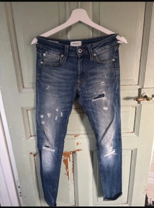 Jack and Jones jeans med slitningar - Säljer nu mina riktigt snygga Jack n Jones jeans, modellen är skinny och storleken är 27:32, passar dock 28:32 eftersom denna model är stor i storleken. Priset går att diskutera och det är bara att höra av sig vid minsta fundering!