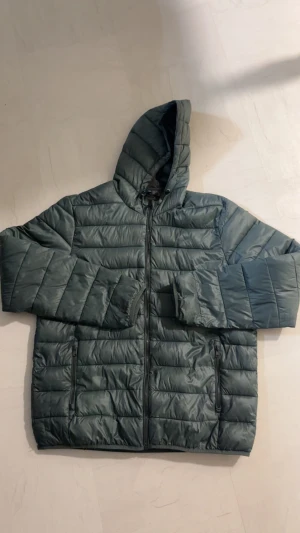 Dunjacka, Vårjacka  - En mörkgrön dunjacka perfekt för vår och lite mildare väder. Storlek L