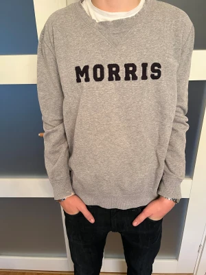 Morris tröja  - Plagget har en svart logotyp med texten Morris.  Perfekt till dig som vill ha en avslappnad och skön stil. 