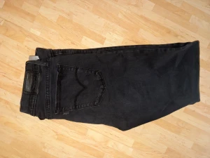 Svarta skinny jeans från Levi's - Svarta jeans från Levi's med klassisk femficksdesign och smal passform. Jeansen har en snygg, mörk tvätt och är tillverkade i stretchigt denim för extra komfort. Perfekt för dig som gillar en stilren och modern look.