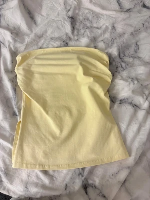 Gul tubtopp från Terranova XS/S - Snygg ljusgul tubtopp från Terranova i mjuk bomullsmix. Enkel och stilren design utan axelband, perfekt för varma dagar. Modellen är bandeau och toppen har en lätt stretchig känsla för skön passform.
