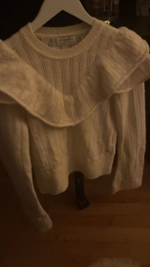 Stickad vit tröja med volanger - Användes max två gånger. Fint skick. Har söta volanger😊
