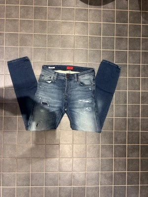 Jack and Jones jeans  - Säljer de här jätte snygga Jack and Jones jeansen i storlek W31 L32 och i modellen Slimfit/glenn, jeansen har en jätte snygg tvätt men även jätte snygga slitningar!