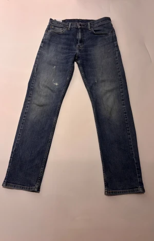 Levis jeans med slitningar - Ett par sjukt feta Levis med snygga slitningar fram och paint splatter skicket är mycket bra. Storlek 32/32 model 505