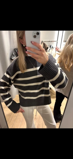 Randig stickad tröja från H&M - Mysig stickad tröja från H&M i mörkgrått och vitt med breda ränder. Modellen är loose fit med ribbade muddar och rund hals. Perfekt för dig som gillar chill och stilren vibe. Passar dig som vill ha en skön och trendig look.