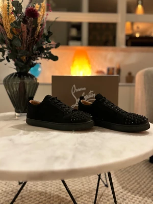 Christian Louboutin skor - Svarta sneakers från Christian Louboutin med snygga svarta nitar. ingen nit saknas och skorna är i mycket bra skick och sparsamt använda. Kontakta mig gärna om du har frågor eller vill ha mer bilder. Priset är inte hugget i sten!