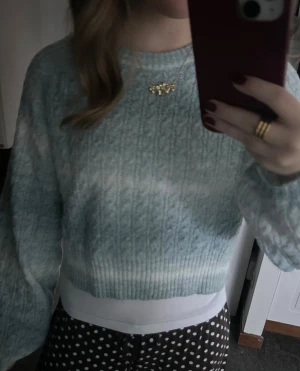 Ljusblå stickad tröja från Vila - Superfin ljusblå stickad tröja från Vila i storlek S. Tröjan har ett klassiskt kabelstickat mönster, ribbad nederkant och långa ärmar. Den är croppad och har en mjuk, cozy vibe som passar perfekt till jeans eller kjol.