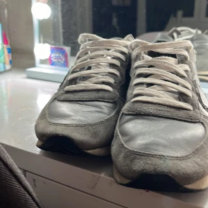 Philippe model skor - Snygga grå sneakers med vit sula och svarta ränder på sidan. Ovandelen är i en mix av skinn och mocka, med vita snören och rund tå. Perfekt för dig som gillar stilrena och klassiska sneakers med lite retrovibe. Ny pris 3500 kan bli billigare vid snabb affär 