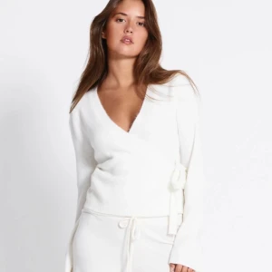 Vit stickad tröja med rosett  - Säljer en vit stickad tröja från 157 har använt den 2 gånger. ( Vet inte Vrf den är så gul på bilden faktiskt) den är lång i ärmarna och mjuk material och sticks inte. Nya priset // 150 🩷