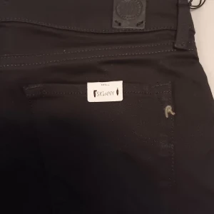 Svarta skinny jeans från Replay - Snygga svarta jeans från Replay i skinny fit med klassisk femficksdesign och diskret Replay-logga vid fickan. Jeansen har smal passform och är tillverkade i stretchigt material för en bekväm känsla. Perfekta för dig som gillar stilrena och tajta jeans. Är alldeles nya och aldrig använda. Tyvärr för små för mig därav säljer jag dom..