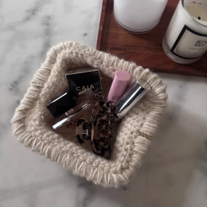 Beige handvirkad clutch  - Säljer en beige handvirkad clutch! Perfekt att använda som en neccesär! 