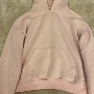 Ljusrosa hoodie från Gina Tricot - Supermjuk ljusrosa hoodie från Gina Tricot, basically basics-kollektionen. Sitter typ som en Xs Klassisk modell med huva, magficka och ribbade muddar vid ärmslut och nederkant. Perfekt för chill dagar och enkel att matcha med jeans eller leggings.