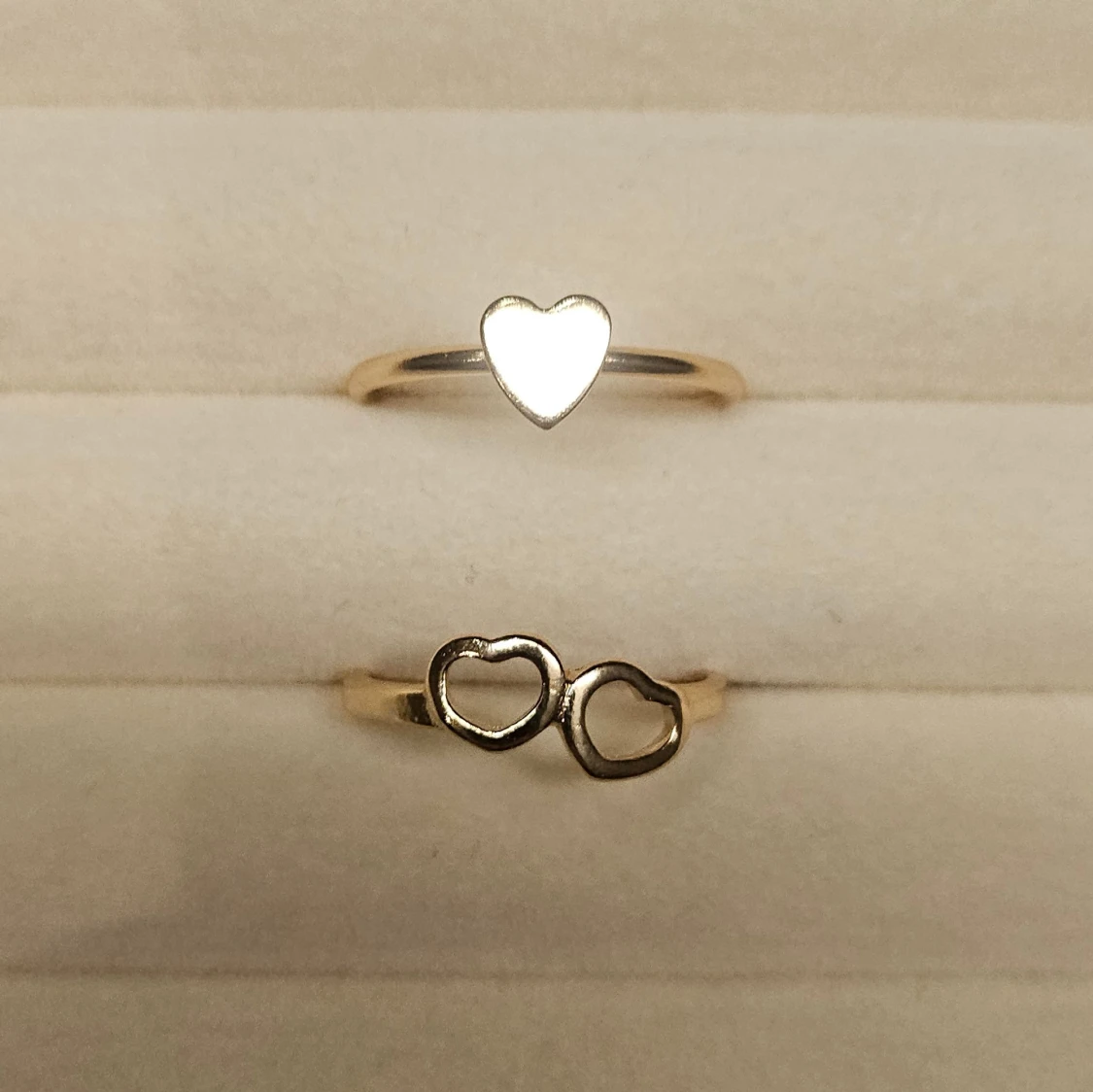 Två guldiga ringar med hjärtan
