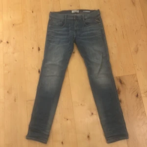 Replay Hyperflex blå jeans, 31/34 - Snygga Replay Hyperflex jeans i blå tvätt med snygg wash och klassisk femficksdesign. Modellen har slim passform och stretchigt material som ger grym komfort. Perfekt för dig som gillar stilrena och moderna jeans med cool look.