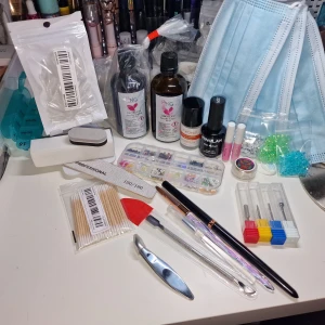 Nagelkit med dekorationer och verktyg - Stort nagelkit med akrylvätska från NG, cuticle remover från TWOING, svart gel polish från MINGLAN, nagelfilar, borstar, verktyg, borstar med glitterhandtag och massor av nageldekorationer i olika färger och former. Perfekt för kreativa nageldesigner hemma.