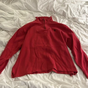 Vintage Röd manchestertröja Polo Ralph Lauren - Riktigt snygg röd långärmad tröja från Polo Ralph Lauren i manchester. Tröjan har half zip med läderdetalj, klassisk broderad logga på bröstet och hög krage. Perfekt för dig som gillar en chill men ändå stilren look. Storlek XL men sitter mer som M/L
