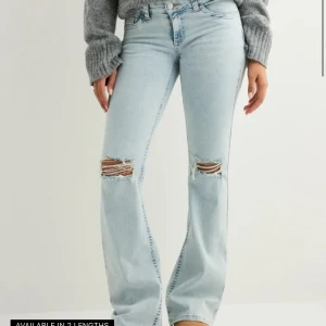 Lågmidjade jeans  - Snygga ljusblå jeans från Nelly med bootcut passform och slitna detaljer vid knäna. Bakfickorna har ett coolt zigzag-broderi i rosa. Jeansen har klassisk femficksdesign och är tillverkade i mjukt denimtyg.