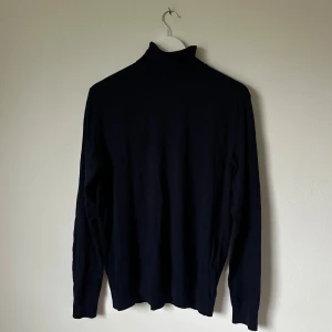 Mörkblå polotröja från SELECTED HOMME - Snygg mörkblå polotröja från SELECTED HOMME i storlek L. Tröjan är tillverkad i 100% bomull och har en klassisk hög krage samt långa ärmar. Perfekt för dig som gillar stilrena och enkla plagg med en chill vibe. 4D13