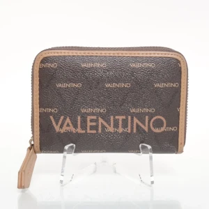 Brun plånbok från Valentino - Snygg brun plånbok från Valentino med logomönster över hela ytan och beige kant. Plånboken har dragkedja runt om och ett stilrent, lyxigt utseende som passar perfekt i väskan. Materialet är skinnliknande och ger en exklusiv känsla.