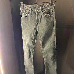 Replay grå slim jeans - Snygga grå jeans från Replay i skinny fit med klassisk femficksdesign och metallknapp framtill. Jeansen har en diskret logotyp på bakfickan och metallpatch vid linningen. Perfekt för dig som gillar en smal siluett och stilren look.