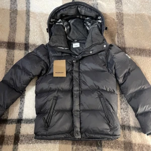 Burberry jacka - Svart pufferjacka från Burberry med avtagbara ärmar❗️, black modell, Jacka & väst. Perfekt för den kommande vintern❄️Jackan är inte använd och kommer med nya tags 🏷️ Värme fickor✅ justerbar jacka✅ ❗️Pris kan diskuteras❗️ inom snabbaffär och bundle köp, men tveka inte och kontakta vid intresse🙌 Frågor och behov om mer bilder?🤔 Kontakta mig gärna⤵️