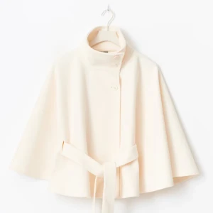 Beige kappa med bälte och hög krage, Gina Tricot Belt Cape Jacket - Snygg beige poncho liknande kappa från Gina Tricot. Den har breda ärmar, hög krage och knappar framtill. Ponchon har ett matchande bälte i midjan som ger en clean och modern siluett. Perfekt för dig som gillar minimalistisk stil och vill ha något som sticker ut med sin coola form. Ångrade mitt köp men hade inte tagit med kvitto, prislapp finns kvar