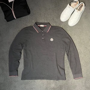 Moncler piké långärmad  - Hejsan allihopa säljer min nygg mörkgrå långärmad pikétröja från Moncler.Tröjan är i mycket fint skick och passar dig som bär storlek M-L. Såklart så är den äkta och det kan bevisas. Jag tär gärna emot byten om du bor i Stockholm och prisförslag. Har du ytterligare frågor är det bara att höra av dig mvh Oscar