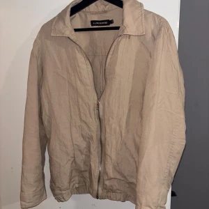 Lindberg jacka  - Beige jacka från LINDBERG litet märke längst ner på armen (försvinner i tvätten) ser skrövlig ut pga att den är nytvättad.                                                     Passar med både mörka och ljusa byxor 