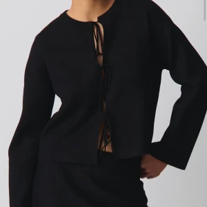 Svart kofta med snörning framtill - Snygg svart kofta med långa ärmar och cool snörning framtill som ger en unik look. Koftan är i mycket bra skick.