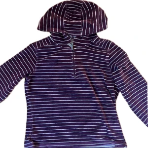 Randig zip från The North Face - Säljer en så cool vinröd och vitrandig hoodie från The North Face. Den har huva, lång ärm och en half zip-dragkedja framtill. 