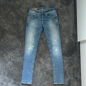 Dondup Jeans - Snygga blå jeans från Dondup, modell George. Jeansen har slitna detaljer och en tvättad look med ljusare partier. Modellen är George. Skicket är som nytt och kontakta om du har några funderingar 