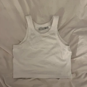Vit ribbad linnetopp från 157 - Säljer en vit croppad linnetopp från 157 i ribbad bomull. Använd fåtal gånger.