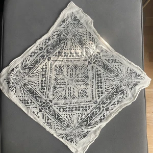 Vit och svart daisy svarf - Snygg scarf i vitt med svart grafiskt mönster och blommiga detaljer. Tunt och lätt material som ger en cool och avslappnad vibe. Perfekt att knyta runt halsen eller i håret för en trendig touch.