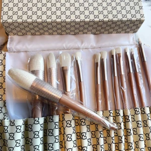  sminkborstar i lyxig förpackning - Exklusivt set med sminkborstar  i beige och guld med vita borst. Setet innehåller flera olika borstar för ansikte och ögon, perfekt för att skapa en flawless look. Kommer i en snygg GG-mönstrad förpackning med grönt och rött band.