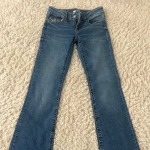 Blå bootcut jeans med normal passform - Snygga blå jeans med klassisk bootcut-modell och normal passform. 