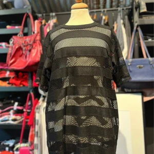 Svart nätklänning från Bik Bok - Svart nätklänning från Bik Bok i meshmaterial med breda, horisontella ränder. Modellen är loose fit och har korta ärmar samt rund halsringning.