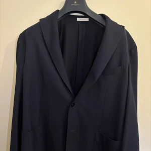 Mörkblå kavaj från Boglioli Milano - Snygg mörkblå kavaj från Boglioli Milano. Perfekt för dig som vill ha en stilren och tidlös look. Nypris: ca 10 tusen