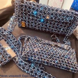 Glittrig kuvertväska med pärlor - Säljer en unik kuvertväska, täckt med glittrande pärlor och stenar i silver och mörkblått. Väskan har en lång axelrem i matchande pärlor och en elegant, rektangulär form. Perfekt för dig som vill sticka ut med en riktigt blingig accessoar.