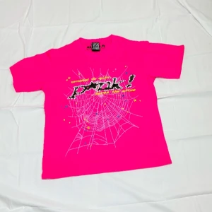 Neonrosa t-shirt från SP5R med tryck - Neonrosa t-shirt från SP5R med coolt spindelnäts- och stjärntryck framtill och en gul stjärna på ryggen. T-shirten har korta ärmar och är gjord i mjuk bomull. Perfekt för dig som gillar färgstarka och unika plagg.