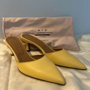 Gula kitten heels från ATP Atelier - Snygga gula kitten heels från ATP Atelier med spetsig tå och låg klack. Aldrig använda, enbart provats på. Lite märken under ena skon från att de prövats ( kan skicka bild vid intresse ) . Kommer med dustbag. Originalpris 3600kr