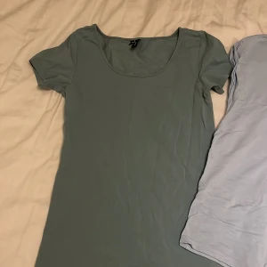 Två basic t-shirts i blå och grön - Säljer två enkla t-shirts, en i ljusblått från Aware och en i dämpad grön från veromoda.  Båda har rund halsringning och korta ärmar. Perfekta för en chill och avslappnad stil. Materialet känns mjukt och svalt mot huden.