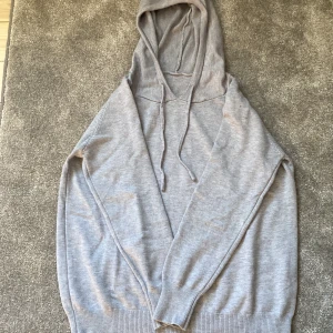 Ljusgrå kashmir hoodie  - En stilren ljusgrå hoodie med ett ny pris på 1800. Töjan har snörning i huvan och långa ärmar. Tröjan är ribbad vid ärmslut och nederkant, vilket ger en snygg passform. Perfekt för dig som gillar en enkel och clean look. Tröjan pass mellan 165-170 centimeter. Den är även använd en gång 